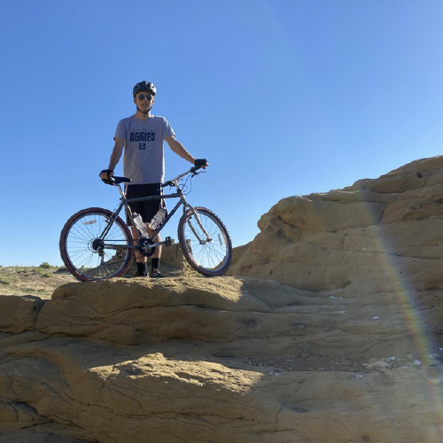 Man at top of hill with mountain bike>