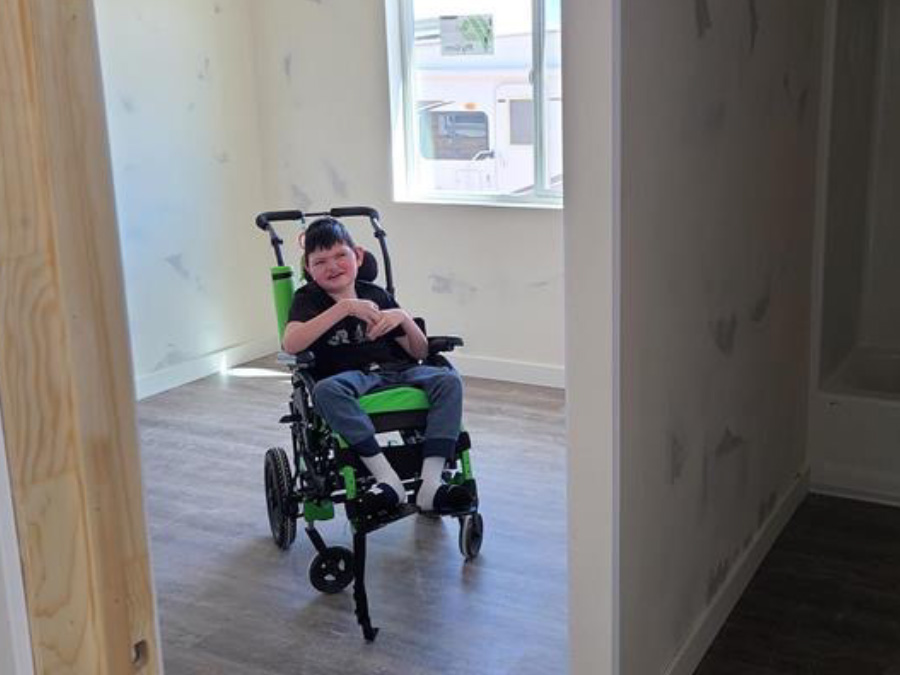 young man in wheelchair in home under construction with accessible doorways