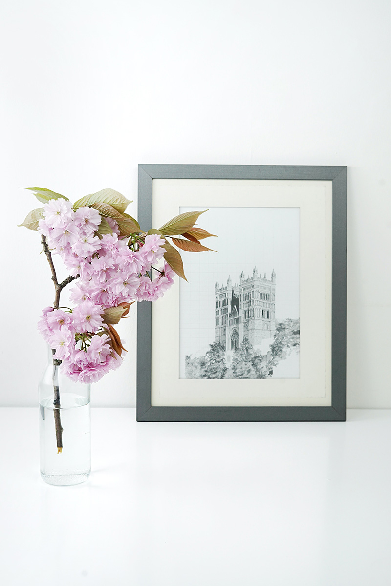 desk with flowers and framed picture showing balance between different objects