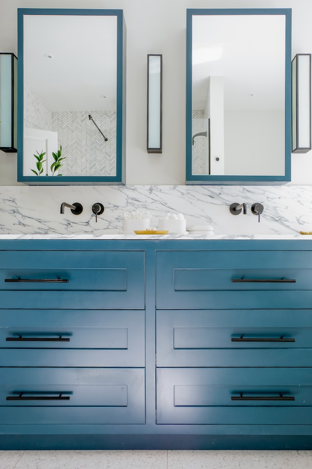 The repetition of the sea blue here in the bathroom cabinets and mirror trim give continuity